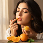 Applying orange lip balm for soft and smooth lips
